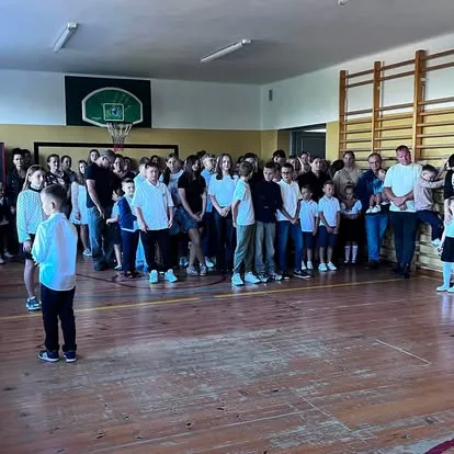 Uczniowie i rodzice w sali gimnastycznej podczas rozpoczęcia roku